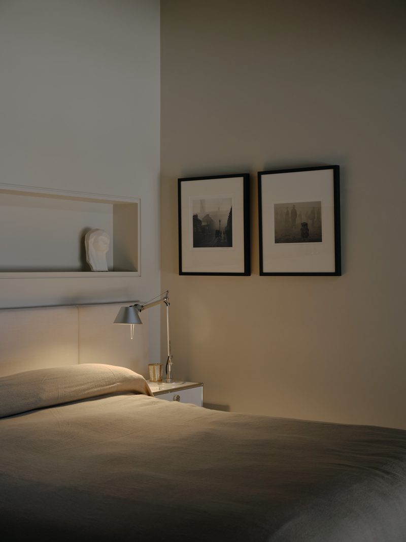 Bedroom with framed photographs and a recessed shelf
