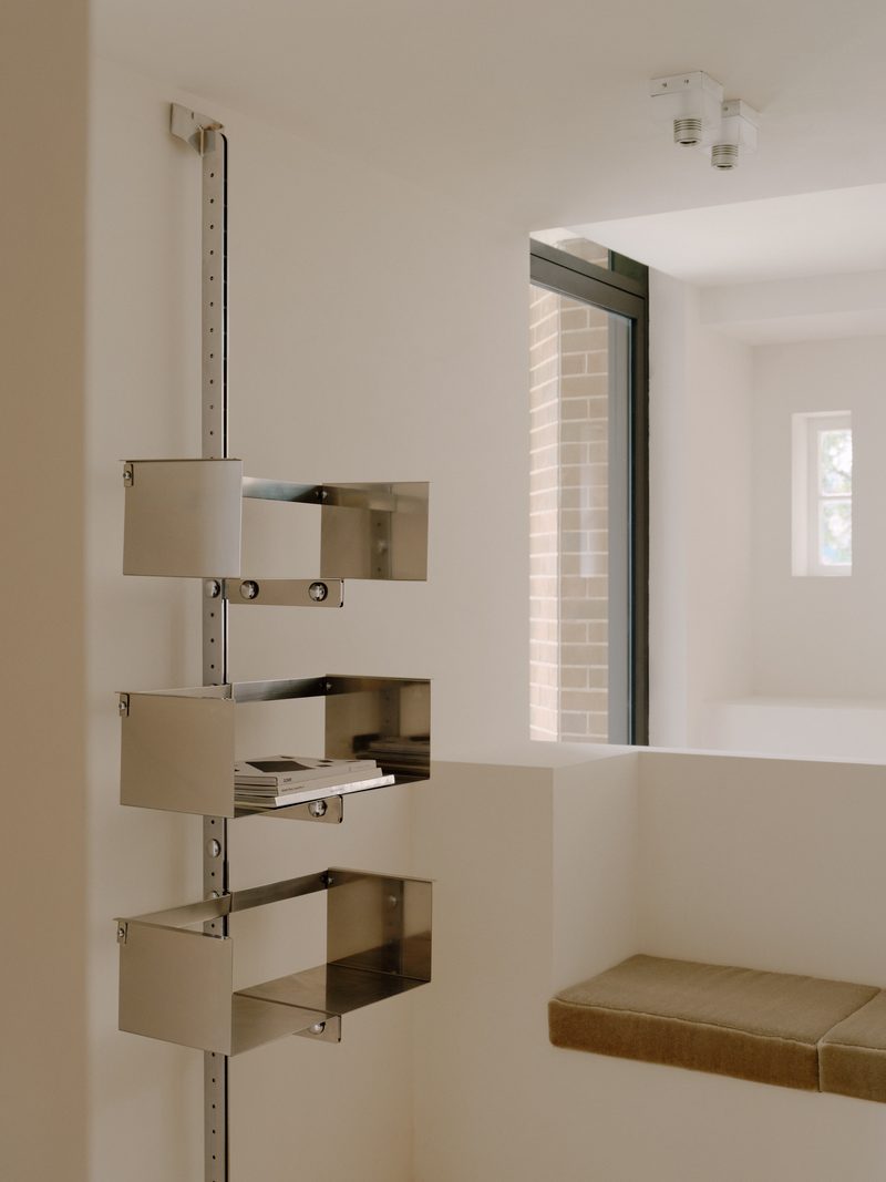 Steel shelving system mounted on a white wall
