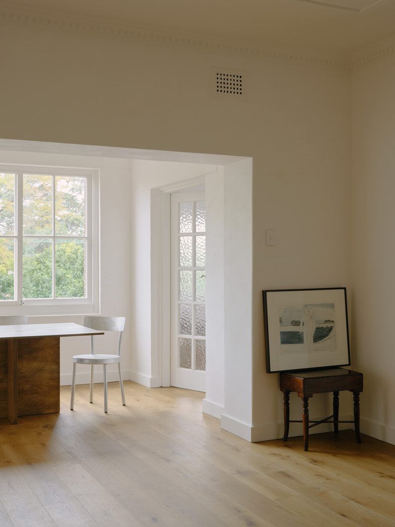 Dining table by a sash window with framed artwork